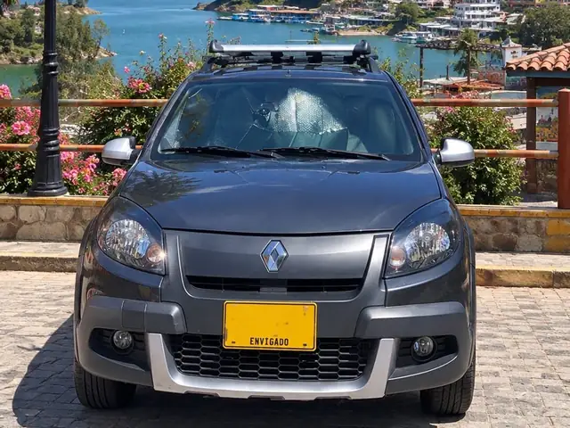 Latidos Tours' dark grey Renault Sandero, front view, with roof bars, by the Guatapé reservoir