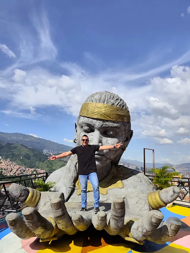 Escultura en un mirador de la Comuna 13 con el valle de Medellín al fondo